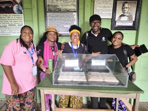 SONTA members inside the First Storey Building in Nigeria, posing behind the First Bible translation by Bishop Samuel Ajayi Crowther, whose portrait is in the background on the wall.